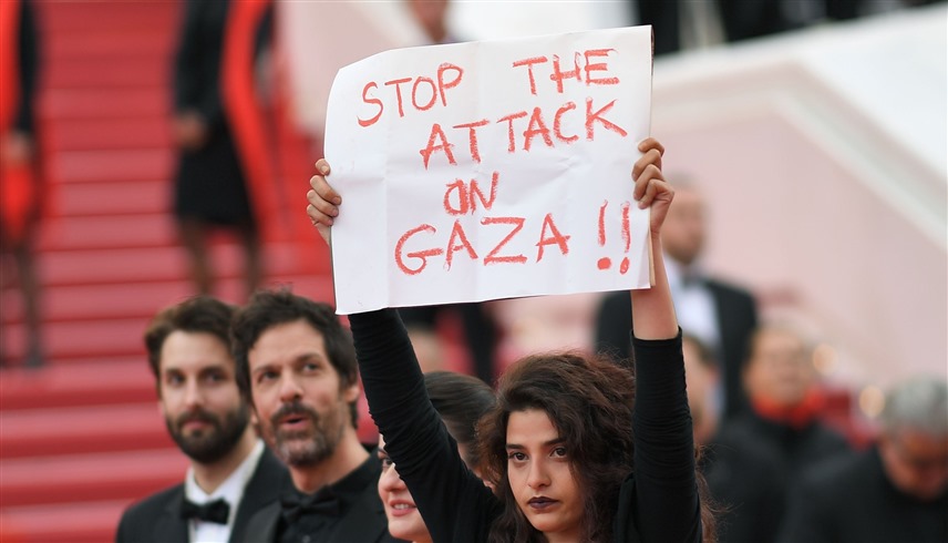 الممثلة اللبنانية منال عيسى ترفع لافتة كتب عليها "أوقفوا الهجوم على غزة" في مهرجان كان 2018